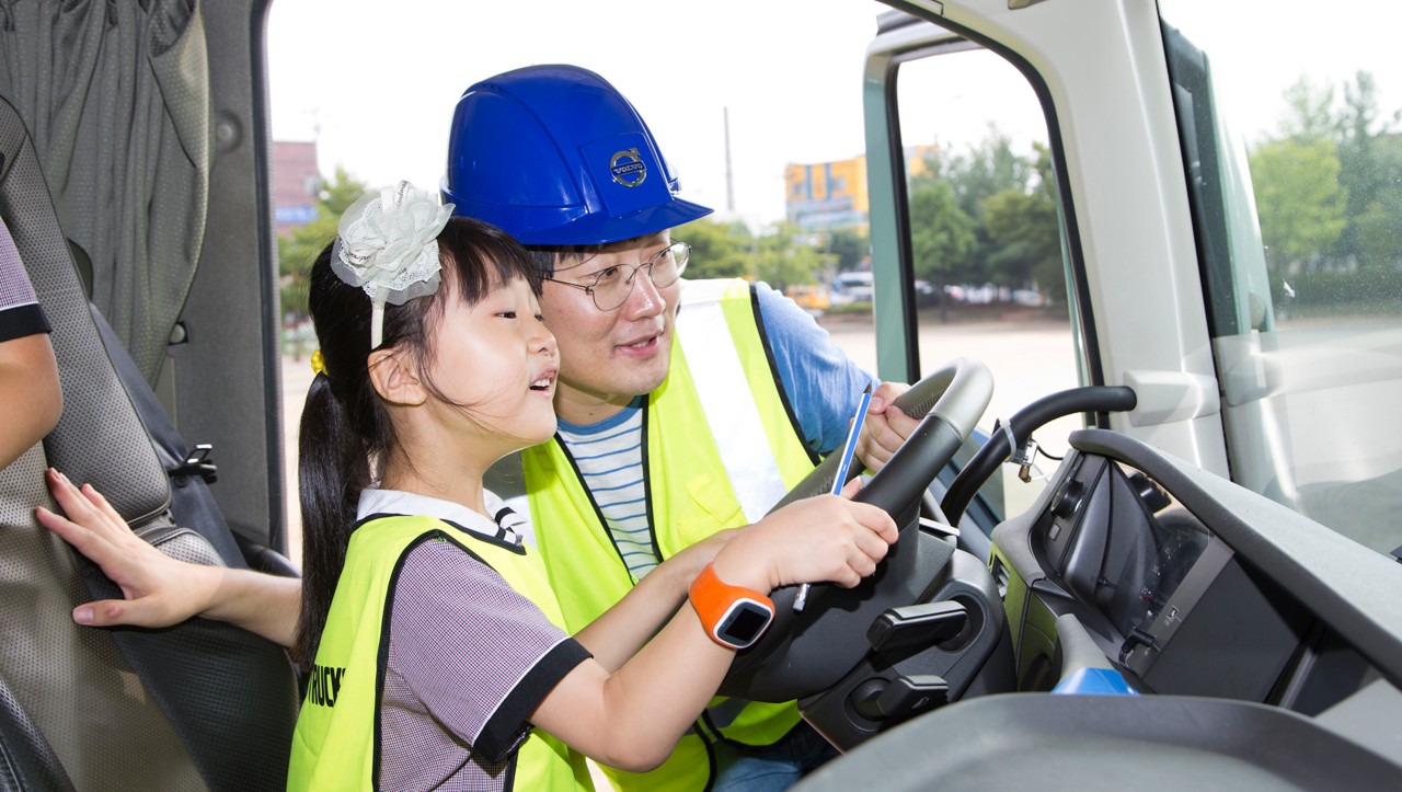 Muž a dieťa sediac na sedadle vodiča nákladného vozidla