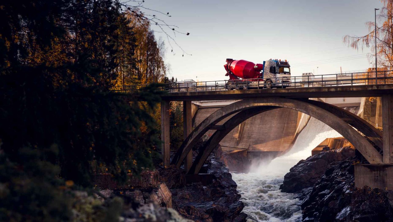 Volvo FMX jazdiace na moste cez rieku