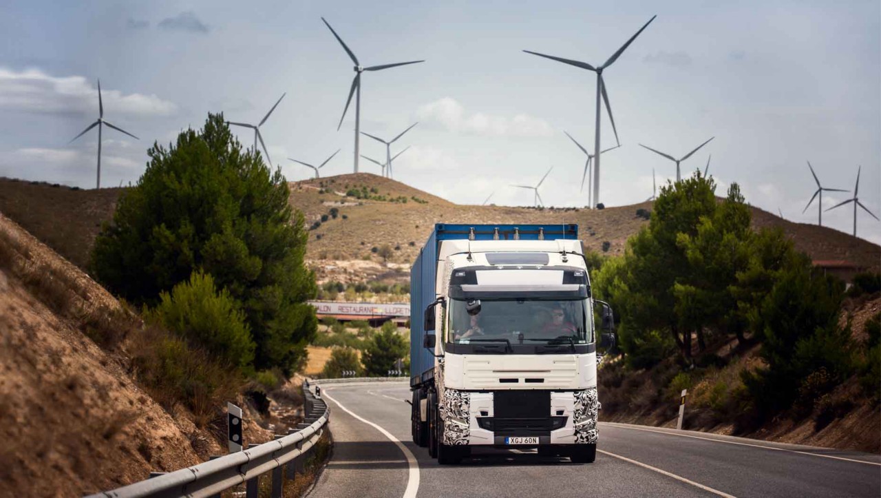Skúšobné nákladné vozidlo na ceste v Španielsku s veternými turbínami v pozadí